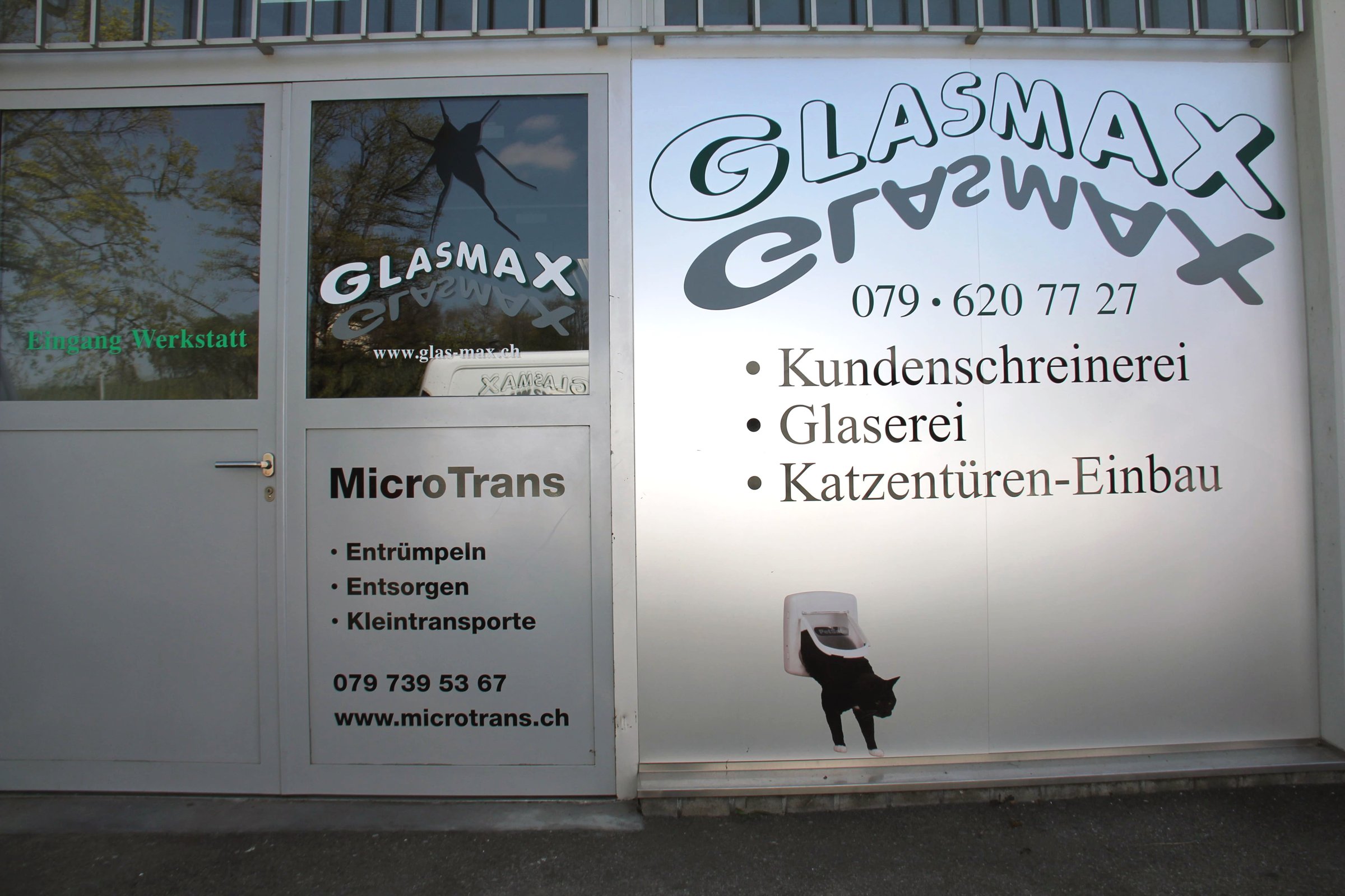 Werkstatteingang von Glasmax mit Schriftzug Kundenschreinerei, Glaserei, Katzentüren-Einbau